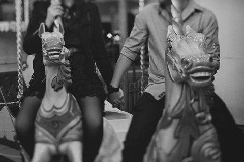holding hands on the carousel at a Luna Park engagement session
