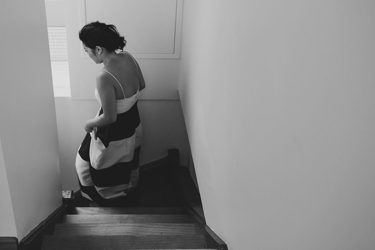 Bride walking down the stairs in her black and white stripe wedding dress